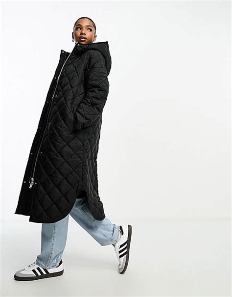 Monki long quilted coat with hood in black .